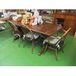 A dark Ercol dining table and six stick back chairs (two carvers, four diners)