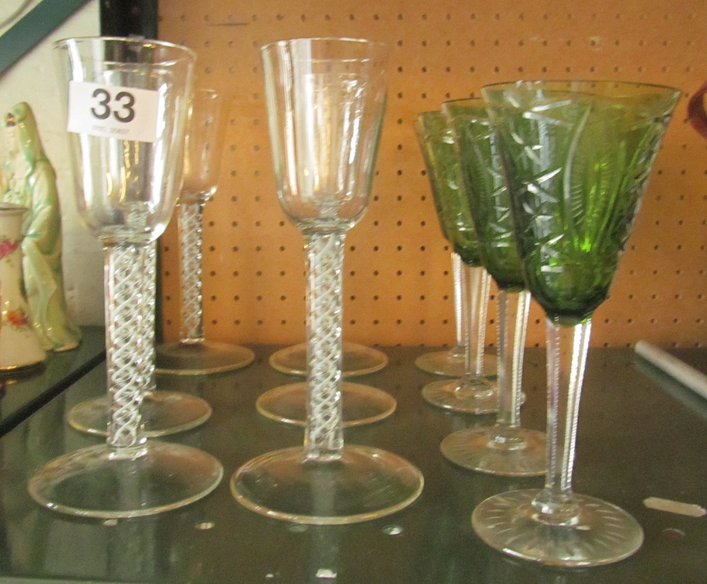 A set of six white airtwist stem glasses and four green drinking glasses