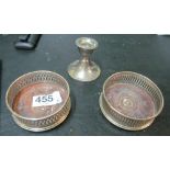 A pair of small silver coasters and a dwarf candlestick