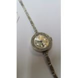 A ladies 18ct gold wristwatch with diamond set bezel on 9ct gold strap