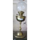 A brass oil lamp with shade and funnel