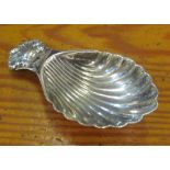 A silver caddy spoon with shell bowl