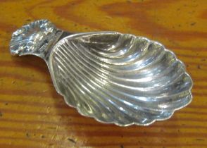 A silver caddy spoon with shell bowl