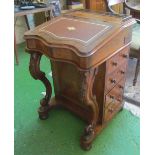 A Victorian walnut Davenport with fitted interior, four side drawers and dummy en verso and carved
