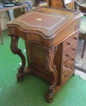 A Victorian walnut Davenport with fitted interior, four side drawers and dummy en verso and carved