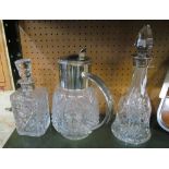 Two silver coloured decanters (replacement stoppers) and a glass jug with plated lid and handle