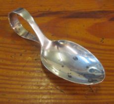 A silver caddy spoon with plain bowl