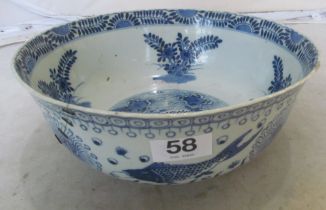 An oriental blue and white fish bowl (rivet repair and chips to rim)