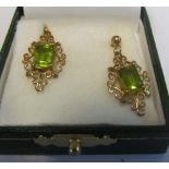 A pair of gold earrings green stones
