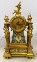 A 19th Century gilt French mantel clock with decorative panels, caryatid columns and cherub to top