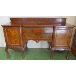 A walnut sideboard, two central drawers on shell capped cabriole legs on claw feet