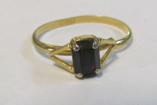 A gold coloured ring set red stone (cut)