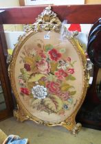 An oval needlework in gilt frame (a/f)