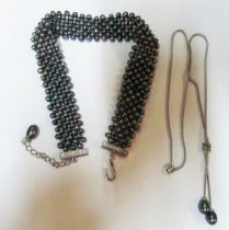 A silver necklace with double pearl drop and a seven band black pearl choker