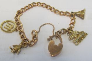 A gold coloured charm bracelet with 9ct padlock clasp, 9ct scorpio charm and other charms