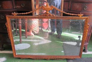 A gilt bevelled wall mirror with urn and swag to top