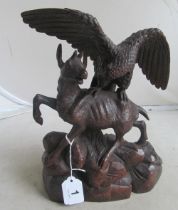 A carved treen group eagle attacking deer on rocky base