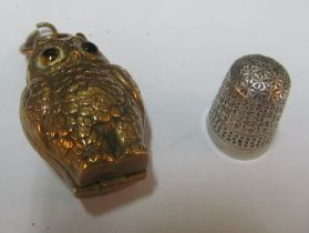 An owl sovereign holder and a silver thimble