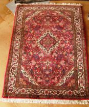 A pink and cream ground floral rug (edges worn)