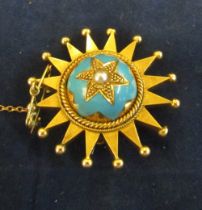 A gold coloured and enamel brooch pendant star design