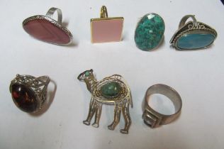 A group of decorative rings and a camel brooch