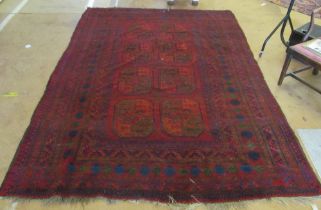 A red Bokhara rug worn