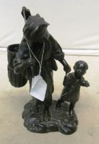 A Japanese spelter figure woman with child holding a trowel and basket, seal mark to base