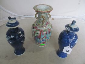 A pair of oriental blue and white lidded vase and a famille rose vase