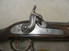 An 1863 Enfield Percussion rifle with ramrod and a gun barrel brush cleaning set