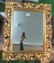 A rectangular mirror with decorative scroll frame