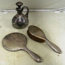 A silver mirror and brush and decanter