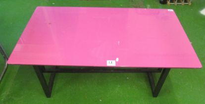 A pink glass top coffee table on metal base with Art Deco design