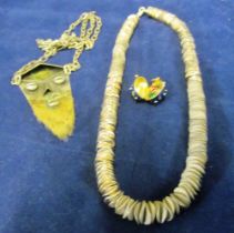 A silver chain necklace, enamel egg pendant and face pendant