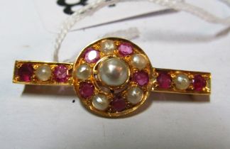 A gold brooch set pearls and garnets