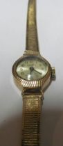 A ladies gold watch and gold coloured bracelet marked 14k