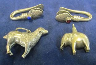 A silver coloured miniature elephant and sheep and two tie napkin holders, marked 925