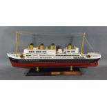 A painted wooden scale model of the Titanic upon rectangular stand, 50cms long