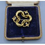An 18ct gold brooch of shaped form set with three diamonds, 9grams, 3cms diameter