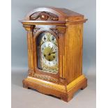 An Edwardian walnut mantle clock with a brass dial, silvered chapter ring with Arabic numerals and