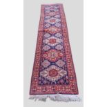 A North west Persian woollen runner with an all over design upon a blue, red and cream ground within