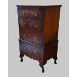 An early 20th Century walnut chest on stand with four drawers raised upon cabriole legs with pad