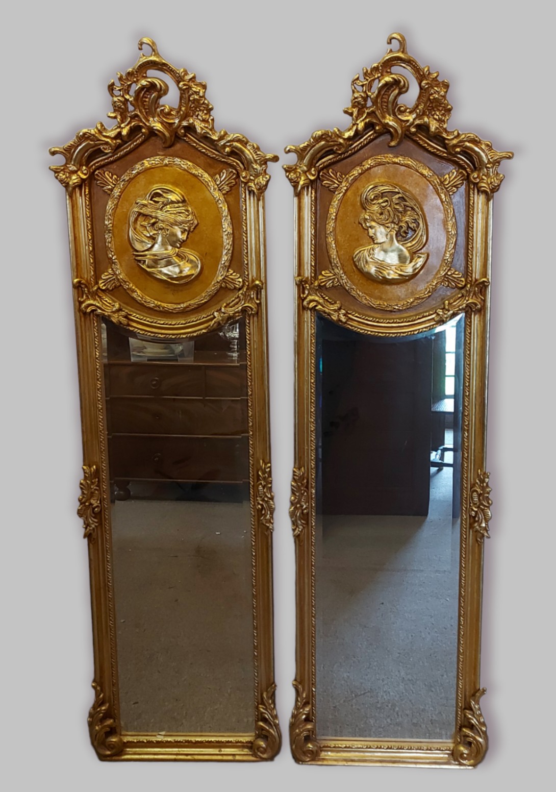 A pair of gilt framed rectangular wall mirrors each with a pierced scroll cresting above a panel