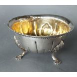 A George III Irish silver bowl with embossed decoration on three shaped supports, Dublin 1784, maker
