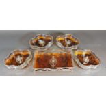 A set of four silver plated and simulated Tortoiseshell bottle coasters of shaped form together with