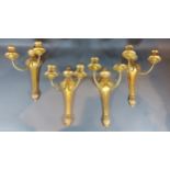 A set of four gilded two branch candle wall lights, 35cms long