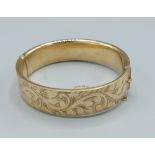 A 9ct gold bangle with engraved decoration, 20.3 grams