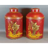 A pair Toleware cannisters, each with gilded decoration depicting figures upon a red ground, 36cms