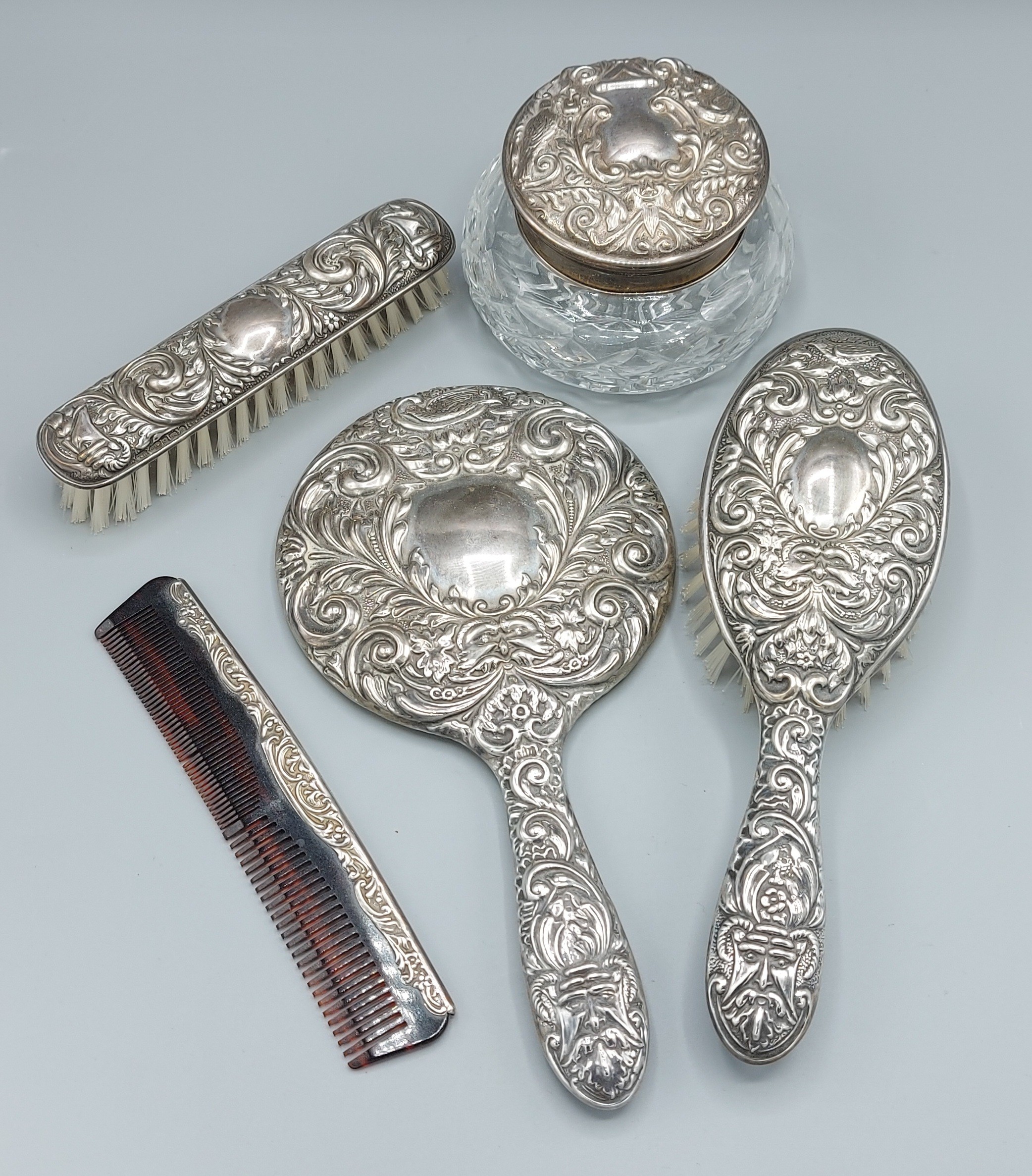 A Birmingham silver five piece dressing table set comprising two brushes, a hand mirror, a comb