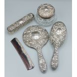 A Birmingham silver five piece dressing table set comprising two brushes, a hand mirror, a comb