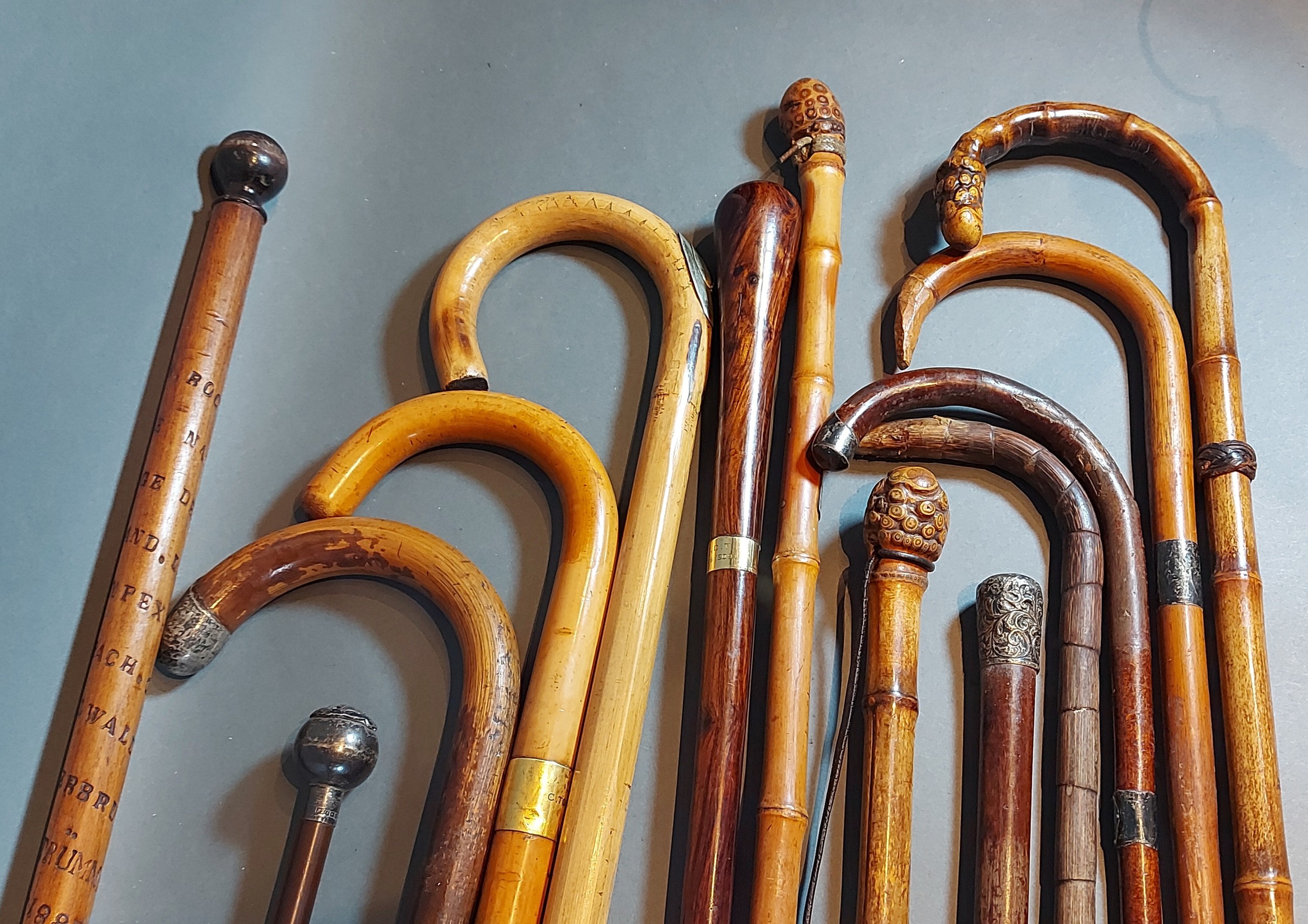 A 15ct gold mounted walking cane together with a collection of other canes, some with silver mounts